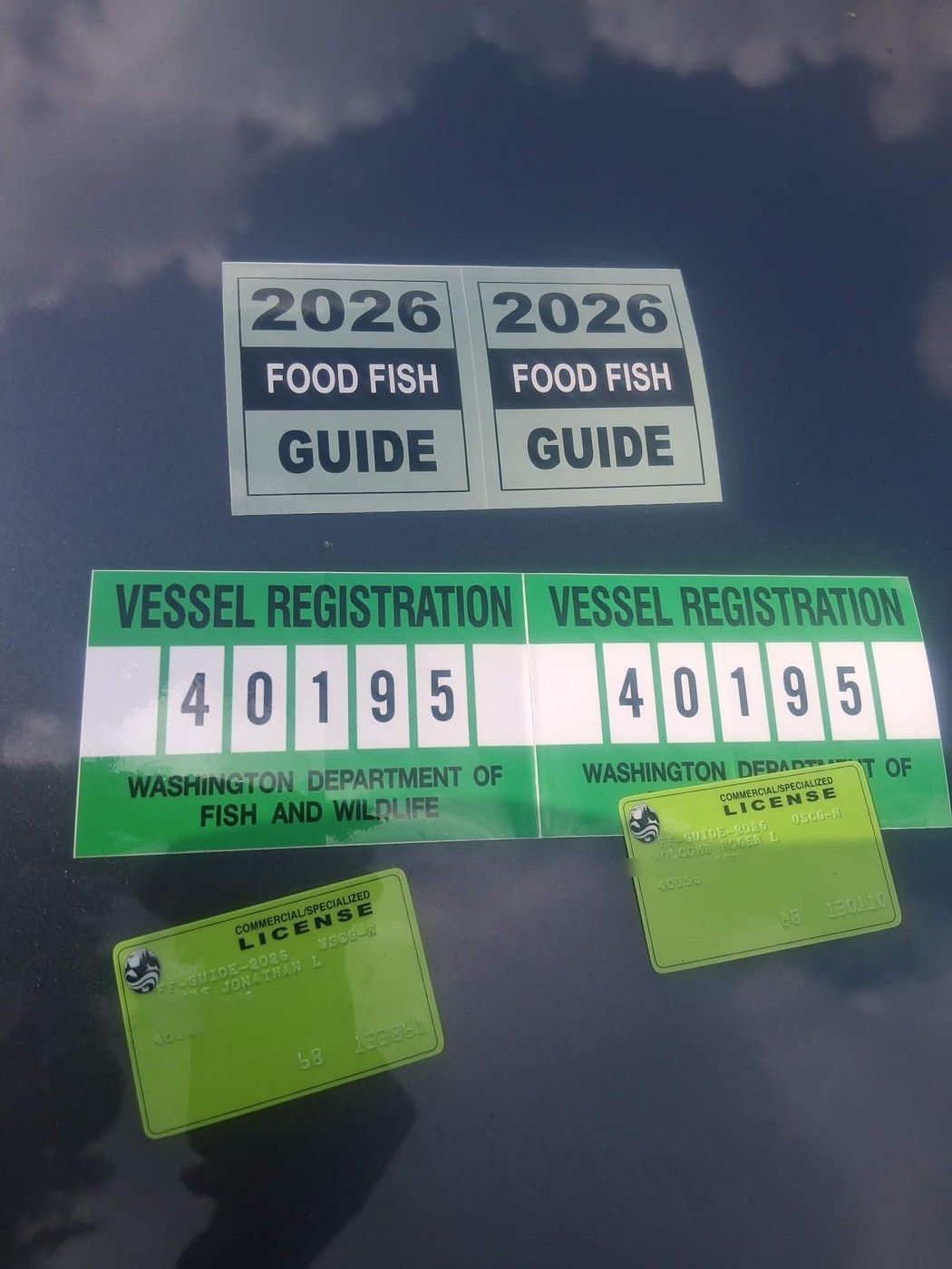 Washington Department of Fish and Wildlife 2026 Food Fish Guide tags, vessel registration stickers, and commercial guide license cards (birthdates blurred)